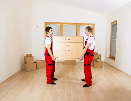 Professional movers carrying boxes and furniture from a Lamorbey property