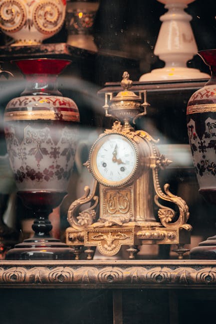 An interior scene of a room during a house removal, showing an ornate wooden sideboard with intricate gold detailing, positioned against a light-colored wall. On top of the sideboard are decorative it